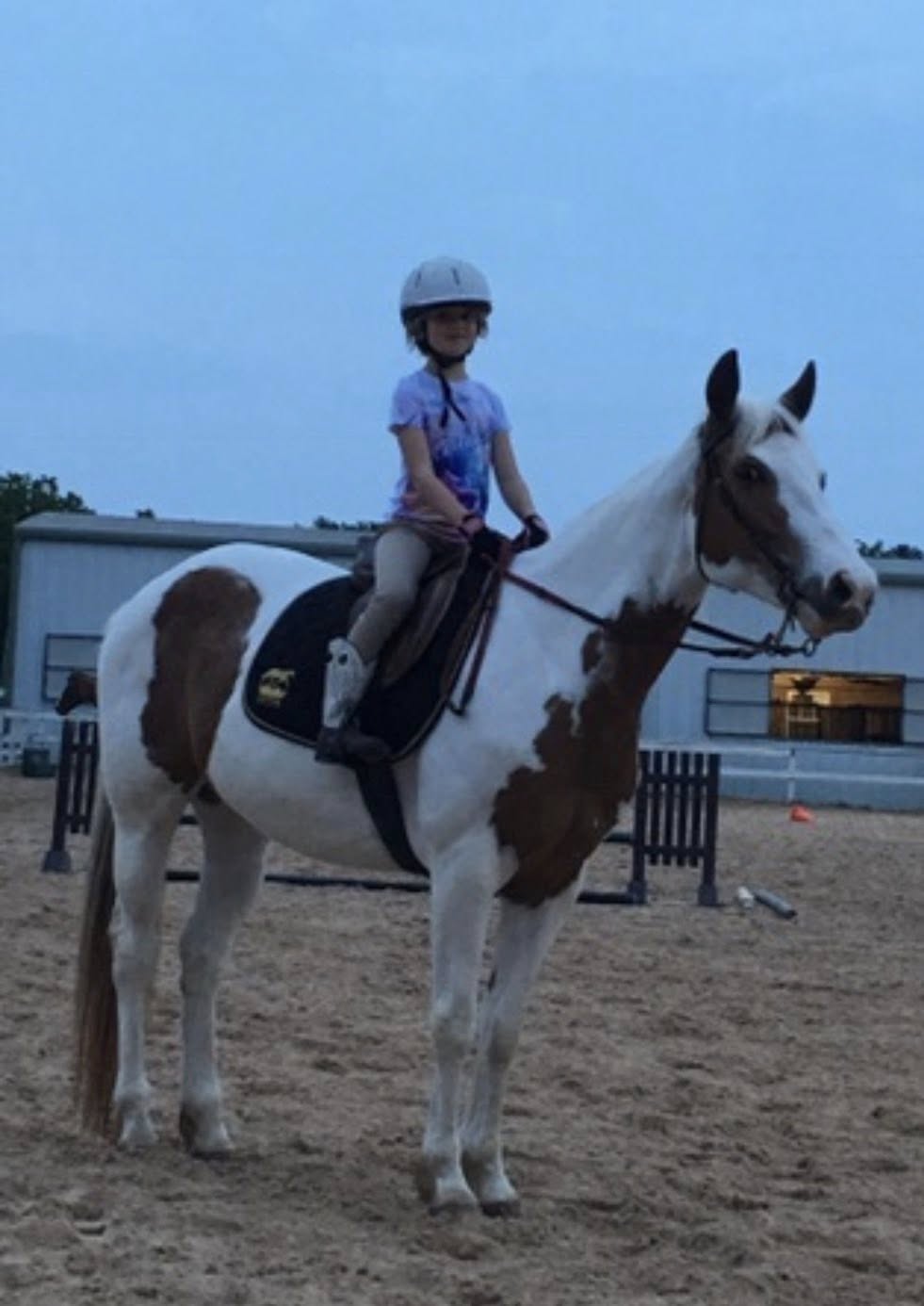 Young rider practicing on paint horse during lesson